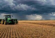 La siembra de trigo avanza con fuerza en Entre Ríos, aunque caerá el área implantada Tractor con sembradora trabajando sobre rastrojo en un campo agrícola argentino, bajo un cielo nublado con tormentas y cortinas de lluvia en el horizonte