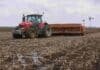 Comenzó la campaña fina 2026/27 con un fuerte avance de la siembra de trigo Tractor Massey Ferguson con sembradora Agrometal realizando siembra de trigo sobre un campo en barbecho con rastrojo de soja y suelo húmedo, con un molino rural visible a lo lejos.