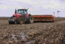 Comenzó la campaña fina 2026/27 con un fuerte avance de la siembra de trigo Tractor Massey Ferguson con sembradora Agrometal realizando siembra de trigo sobre un campo en barbecho con rastrojo de soja y suelo húmedo, con un molino rural visible a lo lejos.
