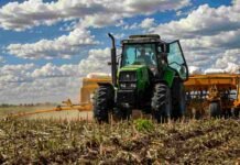 La siembra de trigo avanza a ritmo récord, pero los precios caen por la presión global Tractor verde con sembradora trabajando sobre rastrojo en un lote agrícola argentino, bajo cielo con nubes y colores vívidos durante la siembra de trigo.