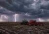 Alerta por tormentas: 60 mm en Buenos Aires y La Pampa Tractor con sembradora de granos finos trabajando sobre rastrojo de soja en la Pampa Húmeda, bajo un cielo de tormenta con relámpagos, lluvia y suelo mojado.