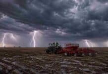 Alerta por tormentas: 60 mm en Buenos Aires y La Pampa Tractor con sembradora de granos finos trabajando sobre rastrojo de soja en la Pampa Húmeda, bajo un cielo de tormenta con relámpagos, lluvia y suelo mojado.