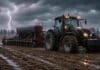 Pronóstico meteorológico agropecuario: vientos con ráfagas y chaparrones marcan el inicio de junio en el campo argentino Tractor Valtra con sembradora de granos finos trabajando sobre un barbecho mojado bajo lluvia intensa, con relámpago en el cielo y suelo embarrado en un campo agrícola.