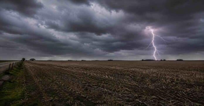 tormenta-relampago-campo-pampeano-invierno Relámpago iluminando un campo agrícola de la región pampeana bajo un cielo cubierto por densas nubes de tormenta, con rastrojo de cultivo y ambiente invernal en una amplia llanura rural argentina