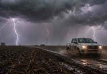 Heladas, tormentas en el NEA y máximas que no superan los 10°C: el pronóstico agropecuario hasta el viernes Tormenta con intensos relámpagos y lluvia sobre un campo en barbecho, mientras una pickup recorre un camino rural embarrado salpicando barro bajo un cielo oscuro.