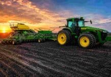 La siembra de trigo avanza en Santa Fe mientras la cosecha sigue condicionada por los excesos hídricos Tractor con sembradora sobre campo en barbecho y suelo húmedo al atardecer, con cielo de colores intensos en una escena agrícola