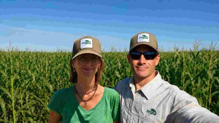 zeta-productores-maiz-campo-ruralnet Dos productores agropecuarios en un lote de maíz bajo cielo despejado.