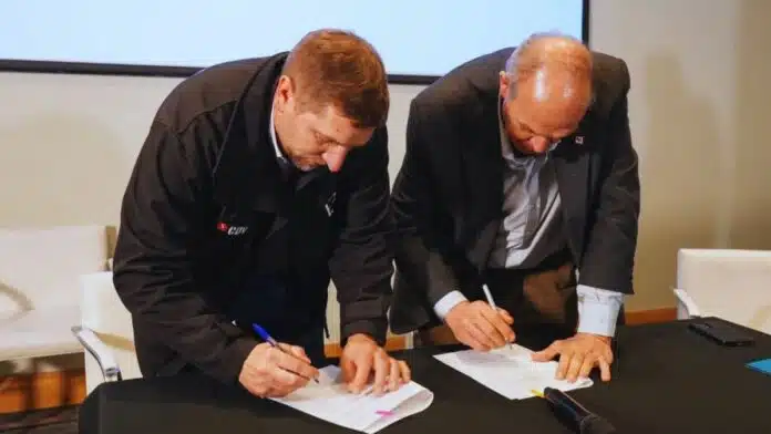 acuerdo-firma-ruralnet Dos representantes firman un acuerdo institucional durante un acto formal.