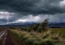 Un frente de tiempo severo activa alertas en 18 provincias Tormenta intensa con rayos, lluvias y fuertes ráfagas sobre un campo rural, con montañas nevadas en el horizonte.