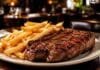 Vacuno, cerdo y pollo coincidieron en Palermo: el mejor momento para las carnes argentinas está por venir Bife de chorizo a la parrilla con papas fritas servido en un restaurante.