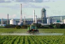 Brasil importa el 85% de sus fertilizantes y decidió que no puede seguir así: el plan que puede cambiar los costos del agro argentino Tractor aplicando fertilizantes en un campo agrícola de Brasil, con una planta industrial de urea y fertilizantes al fondo.