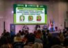 Alertan que la soja necesita ampliar su diversidad genética para seguir aumentando los rindes Auditorio con asistentes durante una conferencia internacional sobre mejoramiento genético y genómica aplicada a la producción animal, con panel de especialistas en el escenario y pantalla de presentación al fondo.