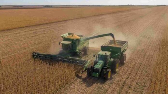Cosechadora y tractor con tolva autodescargable realizando la cosecha de soja en un lote de la región pampeana argentina.