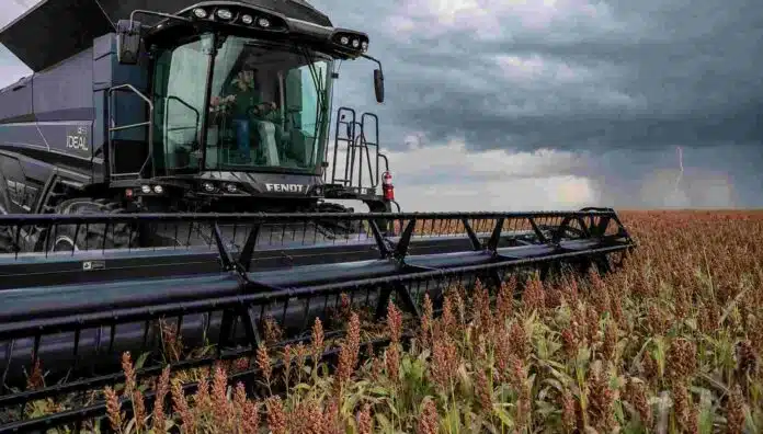 cosecha-sorgo-tormenta Cosechadora Fendt IDEAL recolectando sorgo en un campo argentino, con una tormenta y un relámpago tenue en el horizonte