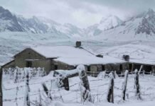 El SMN activa alerta amarilla por nevadas en la cordillera patagónica Casco de estancia patagónica cubierto de nieve, con alambrados nevados y la cordillera de fondo bajo un cielo encapotado.