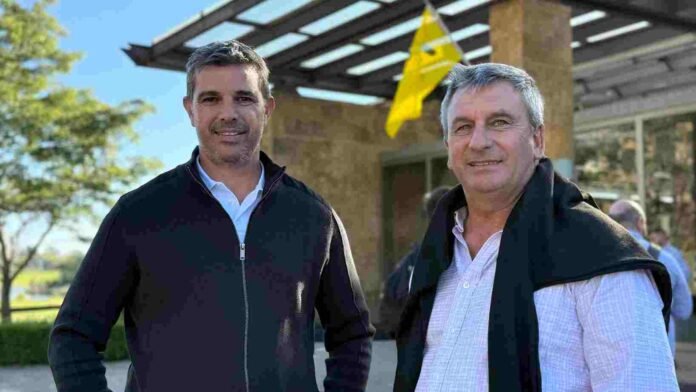 jornada-agricola-productores-campo-ruralnet-nidera Dos referentes del sector agropecuario durante una jornada técnica a campo, posando frente a un establecimiento rural en un encuentro vinculado a la producción agrícola argentina.