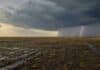 Más lluvias en Buenos Aires y La Pampa: qué anticipa el trimestre agosto-octubre Campo productivo de Buenos Aires y La Pampa bajo lluvias, con suelo húmedo y un relámpago en el horizonte.