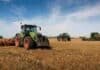 Menor rentabilidad y más importaciones: el desafío de las fábricas de maquinaria Tractor, pulverizadora y cosechadora trabajando en un campo agrícola con rastrojo.