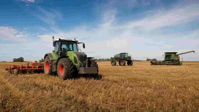 maquinaria-agricola-campo-productivo-ruralnet Tractor, pulverizadora y cosechadora trabajando en un campo agrícola con rastrojo.