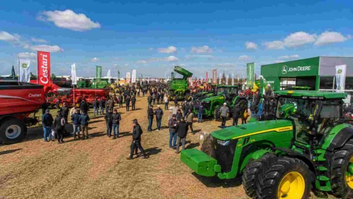 maquinaria-agricola-expo-ruralnet Maquinaria agrícola exhibida en una feria agropecuaria con tractores, stands y público recorriendo la exposición.