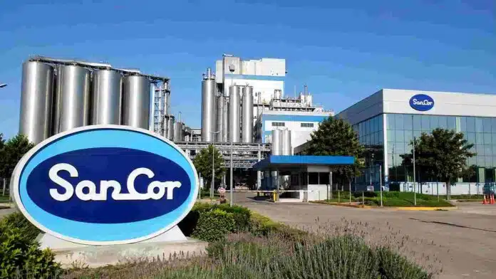 Planta industrial de SanCor con tanques de almacenamiento, edificios de producción y cartelería de la empresa.