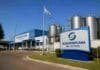 Vendieron Sudamericana de Lácteos: vuelve a producir y mantiene 80 puestos Planta industrial de Sudamericana de Lácteos, con silos de almacenamiento y bandera argentina en la localidad santafesina de Díaz.