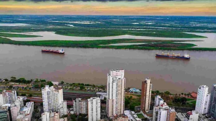 rosario-rio-parana-conferencia-soja-ruralnet Vista aérea de la ciudad de Rosario y el río Paraná, con buques navegando frente a la costa y las islas del delta al fondo.