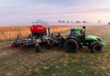 El piloto que lidera el Turismo Carretera ahora también vende sembradoras en el sudeste bonaerense Tractor con sembradora de siembra directa trabajando junto a un lote de maíz en un campo argentino al amanecer con neblina.