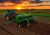 La siembra de trigo ya cubre el 80,9% del área prevista tras mejorar el ritmo de implantación Tractor con sembradora trabajando en un lote agrícola argentino al atardecer, bajo un cielo de tonos anaranjados y dorados, con el sol sobre el horizonte y colores intensos que reflejan el inicio de una nueva campaña agrícola.