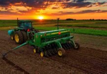 La siembra de trigo ya cubre el 80,9% del área prevista tras mejorar el ritmo de implantación Tractor con sembradora trabajando en un lote agrícola argentino al atardecer, bajo un cielo de tonos anaranjados y dorados, con el sol sobre el horizonte y colores intensos que reflejan el inicio de una nueva campaña agrícola.