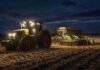 Complica la humedad el tramo final de la siembra de trigo en Santa Fe y el sur agrícola Tractor Claas con sembradora de Industrias Alter realizando la siembra de trigo de noche sobre un campo con rastrojo de maíz, con luces encendidas y cielo parcialmente nublado.