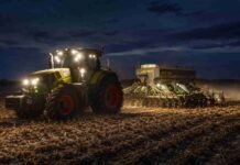 Complica la humedad el tramo final de la siembra de trigo en Santa Fe y el sur agrícola Tractor Claas con sembradora de Industrias Alter realizando la siembra de trigo de noche sobre un campo con rastrojo de maíz, con luces encendidas y cielo parcialmente nublado.