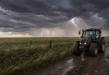 Se activa la inestabilidad: tormentas aisladas, ráfagas y heladas alcanzan al campo hasta el viernes Tractor Valtra en un camino rural húmedo bajo un cielo de tormenta, con pastizales movidos por el viento, cortinas de lluvia y un relámpago sobre el campo argentino.