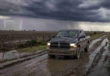 El SMN alerta por tormentas fuertes en cuatro provincias: hasta 50 mm y granizo Camioneta 4x4 circula por un camino rural embarrado mientras una fuerte tormenta con relámpagos avanza sobre la Pampa Húmeda