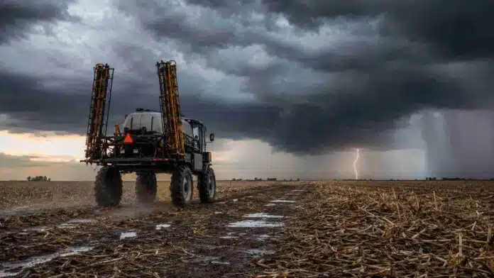 tormentas-lluvias-pulverizadora-campo-ruralnet Pulverizadora autopropulsada con los botalones plegados se retira de un campo con rastrojo de maíz ante una tormenta.