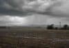El viernes concentra las tormentas: qué cambia durante el fin de semana Frente de tormenta con lluvias sobre un campo de la región pampeana y un molino rural.
