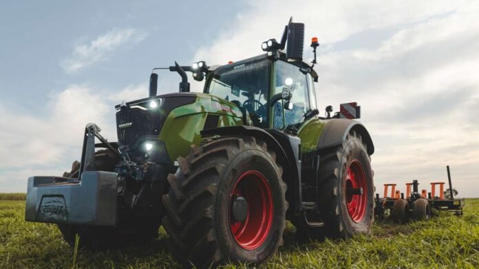 tractor-fendt-700-vario-campo-ruralnet Tractor Fendt 700 Vario trabajando en un campo con implemento agrícola bajo un cielo parcialmente nublado.