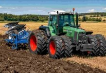 El tractor que revolucionó la transmisión agrícola cumple 30 años y Fendt lo celebra con solo 300 unidades especiales Tractor agrícola verde con arado trabajando sobre un lote cosechado, removiendo el suelo en un campo rural bajo cielo despejado.