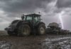 Vuelven las lluvias y la inestabilidad: el pronóstico para el campo hasta el sábado Tractor Valtra con sembradora Pierobon de granos finos trabajando en un campo en barbecho, con suelo mojado, lluvia y un relámpago bajo cielo nublado.