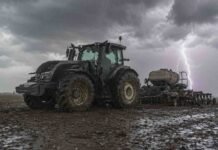 Vuelven las lluvias y la inestabilidad: el pronóstico para el campo hasta el sábado Tractor Valtra con sembradora Pierobon de granos finos trabajando en un campo en barbecho, con suelo mojado, lluvia y un relámpago bajo cielo nublado.