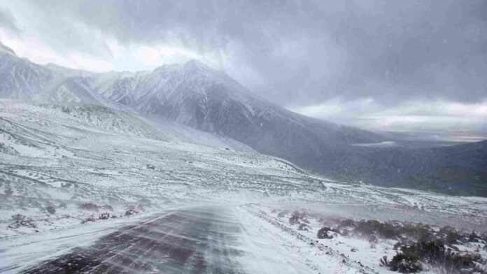 alerta-nevadas-viento-blanco-cordillera-argentina Ruta cordillerana cubierta de nieve durante un temporal con fuertes ráfagas, visibilidad reducida y condiciones de viento blanco.