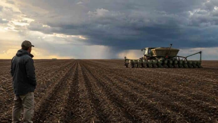 el-nino-estrategias-siembra-campana-2026-27 Productor observa una sembradora trabajando bajo un cielo de tormenta ante el aumento de El Niño y los ajustes de siembra para la campaña 2026/27.
