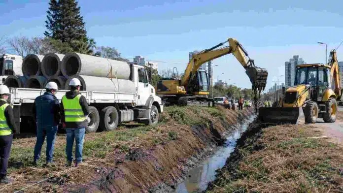 Maquinaria vial e hídrica trabajando en la limpieza de un canal y la colocación de tubos en la ciudad de Santa Fe.