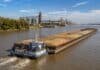 Cabotaje fluvial de granos alcanzó un récord en cinco años Convoy de barcazas con granos navega por la Hidrovía Paraguay-Paraná frente a terminales portuarias y silos.