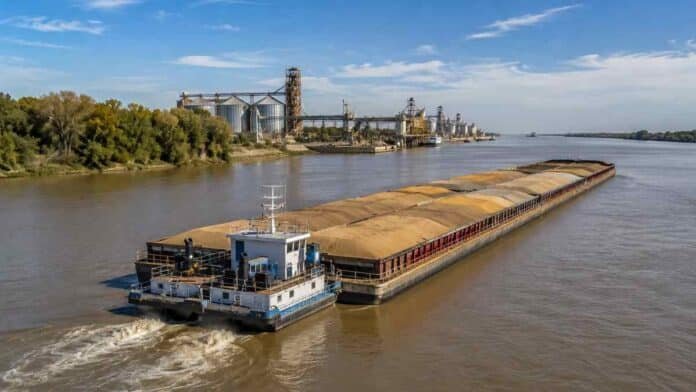 hidrovia-paraguay-parana-transporte-granos Convoy de barcazas con granos navega por la Hidrovía Paraguay-Paraná frente a terminales portuarias y silos.