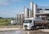 Saputo y Mastellone lideran: las 10 empresas que más leche procesan en Argentina Planta industrial láctea con camión cisterna, tanques de procesamiento y vacas lecheras en el entorno productivo.