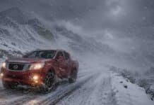 Se intensifican las nevadas: hasta 50 cm, ráfagas de más de 100 km/h y alertas en 11 provincias Pickup 4x4 roja con cadenas en los neumáticos circulando por una ruta de montaña nevada en la cordillera patagónica, con viento blanco y baja visibilidad.