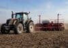 Avanza la siembra de girasol en el NEA y pisa el freno en el centro del país Tractor Valtra con sembradora Crucianelli realizando la siembra de girasol en un lote agrícola, con suelo trabajado y cielo despejado.