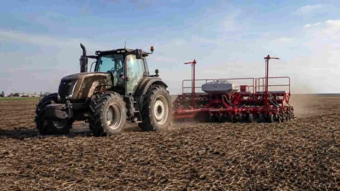 siembra-girasol-tractor-valtra-sembradora-crucianelli Tractor Valtra con sembradora Crucianelli realizando la siembra de girasol en un lote agrícola, con suelo trabajado y cielo despejado.