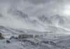 Nieve, viento y Zonda: el SMN alertó a ocho provincias Tormenta de nieve en la Cordillera de los Andes entre Mendoza y San Juan, con una fila de camiones detenidos por el temporal y un arriero con hacienda a la distancia.